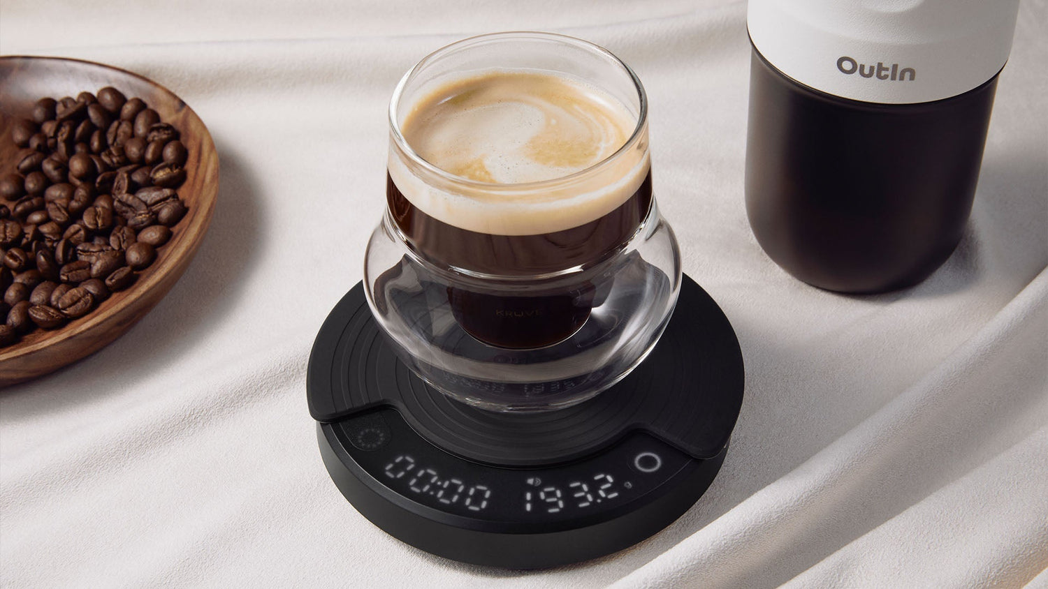 Outln coffee brewing system with digital scale displaying precise measurements for optimal coffee-to-water ratio, showing freshly brewed coffee with crema and whole beans nearby